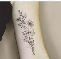 a woman's arm with flowers and leaves on the left side of her body