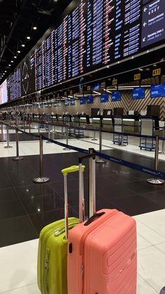 two suitcases sitting on the ground in an airport