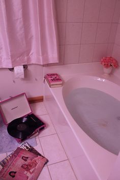 a bath tub sitting next to a magazine on the floor