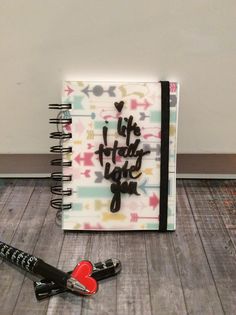 a notebook and pen sitting on top of a wooden floor