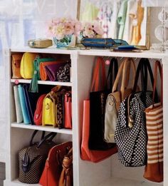 several purses and handbags are hanging on a shelf in a room with white walls