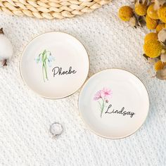 two personalized plates with flowers on them next to a basket and cotton swab