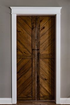 an open wooden door in a room with white trim on the walls and wood flooring