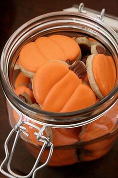 a glass jar filled with cookies on top of a wooden table