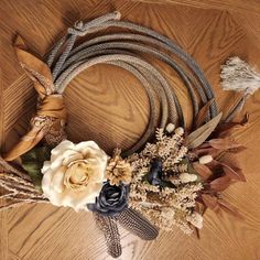 an arrangement of flowers and feathers on a wooden table with a cowgirl's head