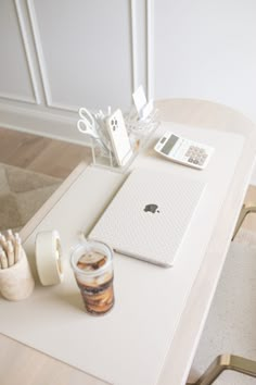 an apple laptop computer sitting on top of a table next to a cup of coffee