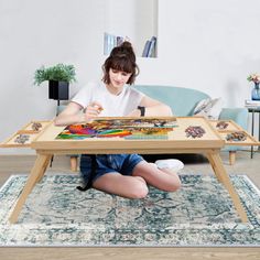 a woman sitting on the floor in front of a coffee table