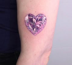 a woman's arm with a heart shaped diamond tattoo on the left inner arm