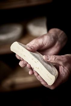 a person holding something in their hand with one hand on the other and another hand over it