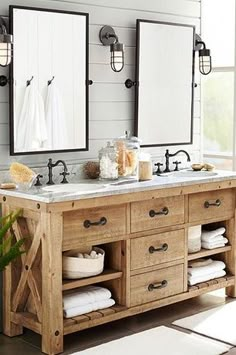 a bathroom with two sinks, mirrors and towels on the counter top in front of it