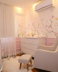 a baby's room with flowers painted on the wall