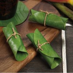 three pieces of green leafy food on a cutting board