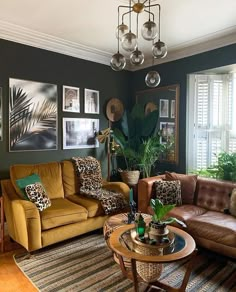 a living room with couches, chairs and pictures hanging on the wall above them