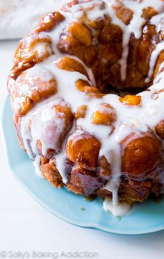 a blue plate topped with a monkey bread covered in icing