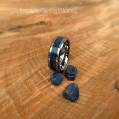 a wooden table topped with rocks and a ring on it's side next to some blue stones