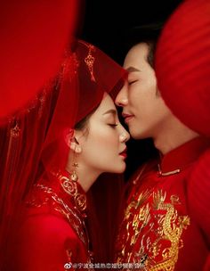 two people dressed in red are kissing each other