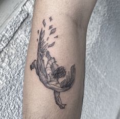 a tattoo on the arm of a person with a bird flying over it's head