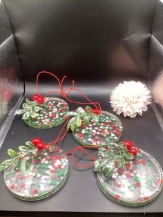 four glass coasters with holly and berries on them