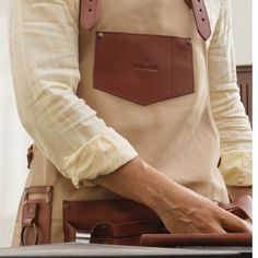 a man in an apron holding a brown bag