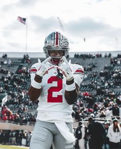 a football player holding his hands up in the air