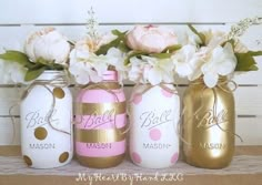 three painted mason jars with flowers in them sitting on a shelf next to each other