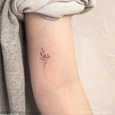 a small flower tattoo on the arm