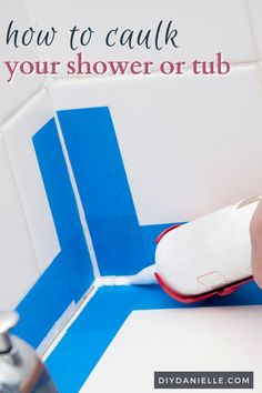 a person is using a brush to clean the tile on a bathroom wall with blue and white tiles