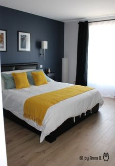 a bedroom with blue walls and white bedding has yellow pillows on the headboard