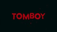 the word tomboy written in red on a black background