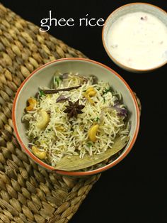 a bowl filled with rice and vegetables next to a small bowl of yogurt