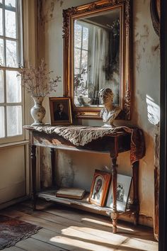 an antique console table in front of a large mirror and vase with flowers on it