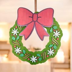 a green wreath with a pink bow hanging from it