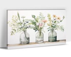 three vases with flowers are sitting on a shelf