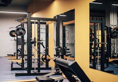 the gym is equipped with many different types of machines and weight racks for strength training