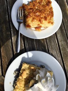 two plates with desserts on them sitting on a wooden table next to each other