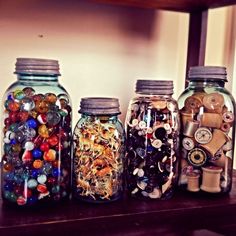 three jars filled with lots of different types of beads