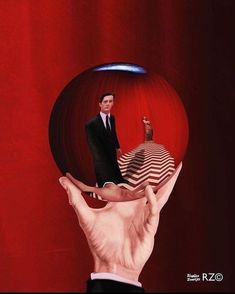 a man in a suit and tie is reflected by a red ball with his hands