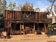 an old wooden building with a clock on the front