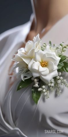 a bridal bouquet with white flowers and greenery on the bride's dress