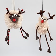 two christmas decorations made to look like sheeps hanging from strings with eyes and noses