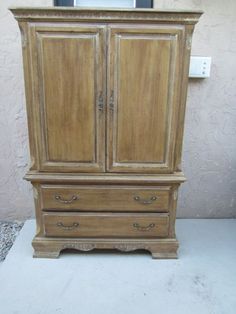 an old wooden armoire sitting on top of a white floor next to a wall