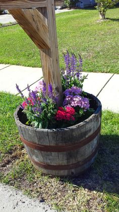 a wooden barrel filled with lots of flowers