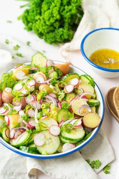 a salad with radishes, cucumbers and parsley in a bowl