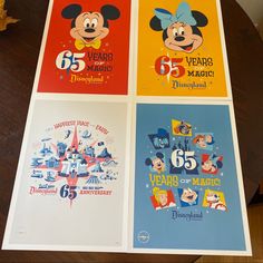 four mickey mouse posters on a table with the numbers 55, 65, and 75