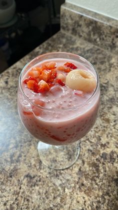 a glass filled with fruit on top of a counter