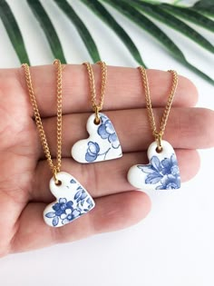 two heart shaped ceramic pendants in blue and white on a gold plated chain