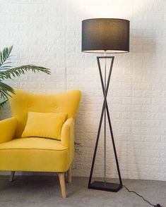 a yellow chair sitting next to a black lamp