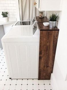 a washer and dryer sitting next to each other in a room with black and white tile flooring