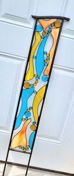 a stained glass window hanging on the side of a garage door in front of a white door