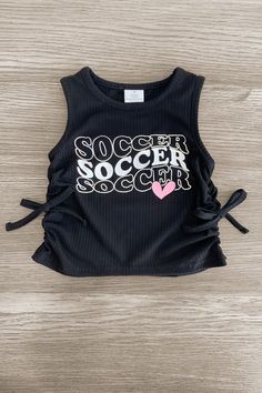 a black shirt with the words soccer on it and a pink heart in the center